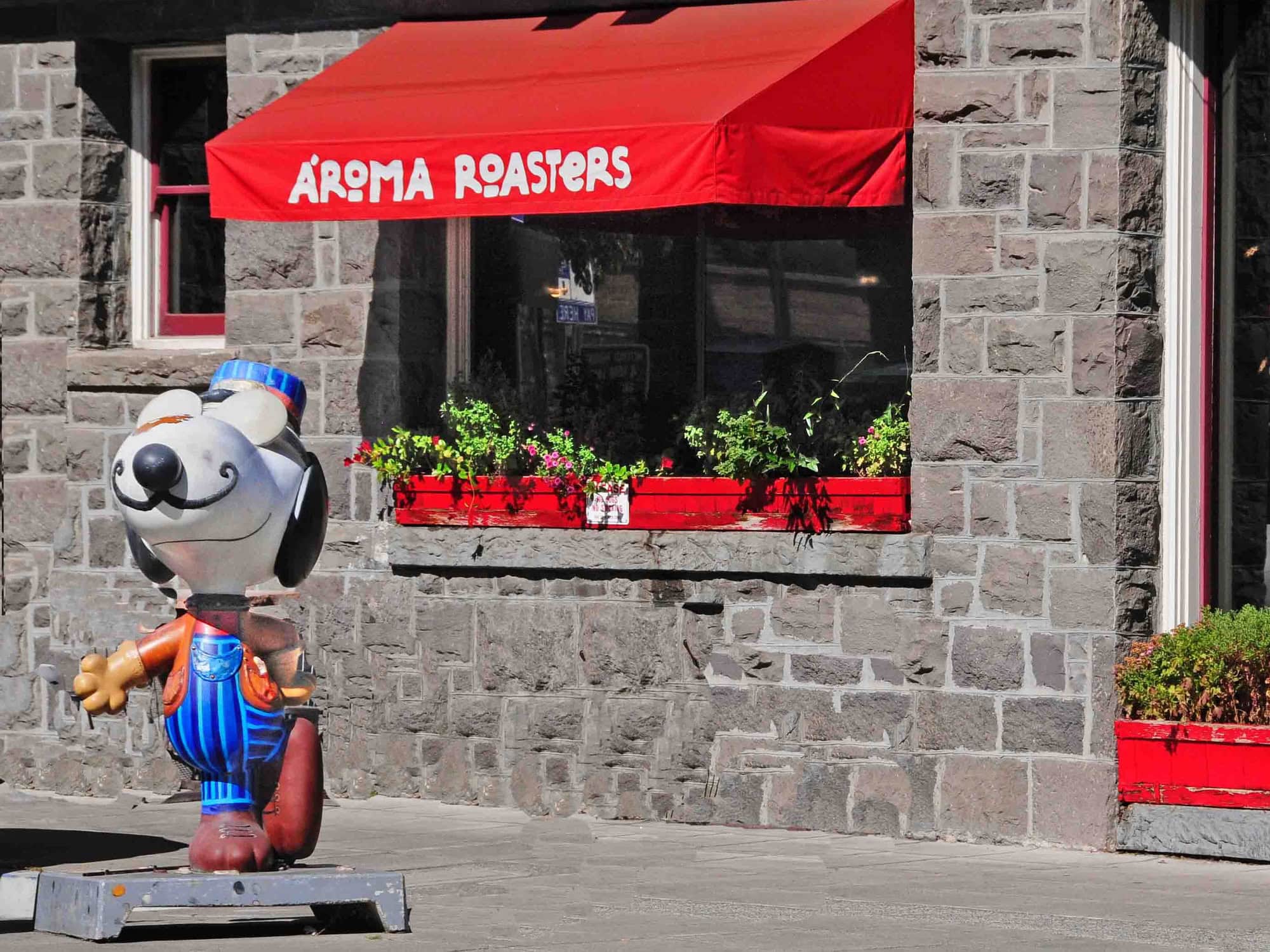 A statue of Snoopy sits out in front of the stone cafe in Sonoma County