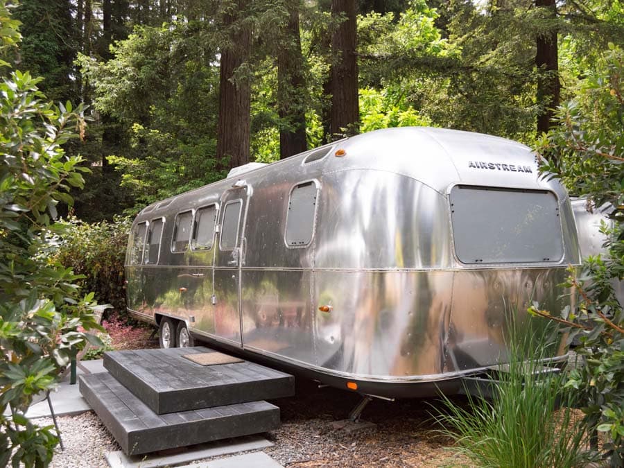 A silver airstream trailer is surrounded by redwoods in Sonoma County