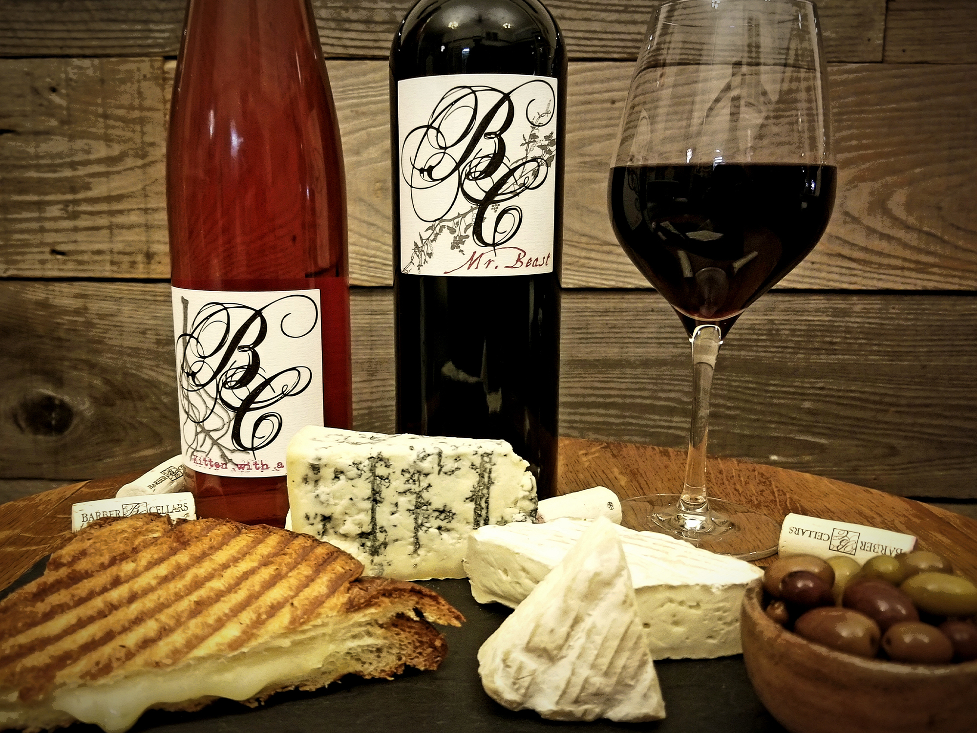 A bottle and a glass of wine next to cheese ready for a pairing