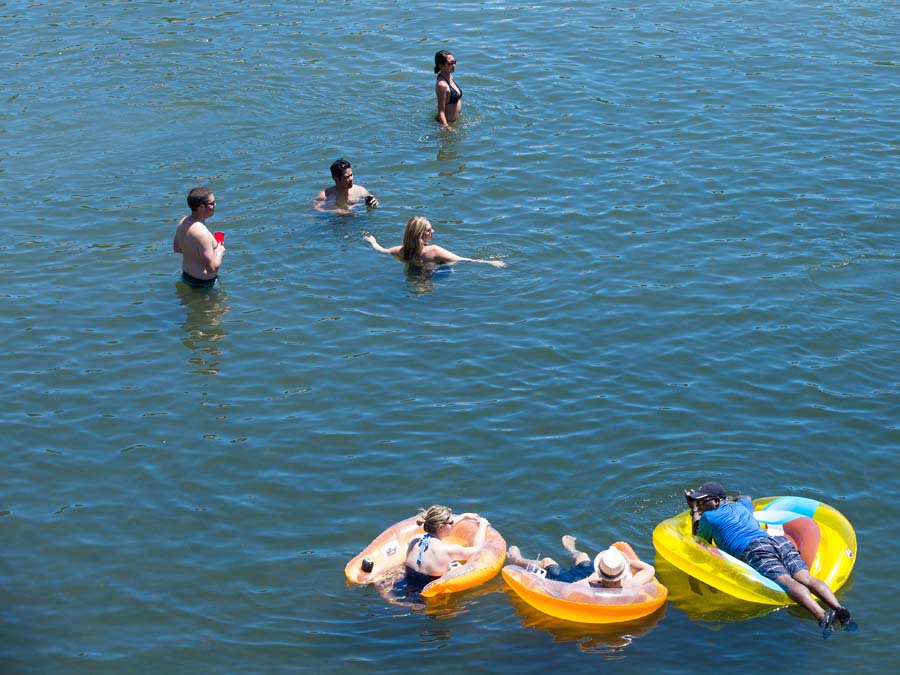 People float on inner tubes in blue water