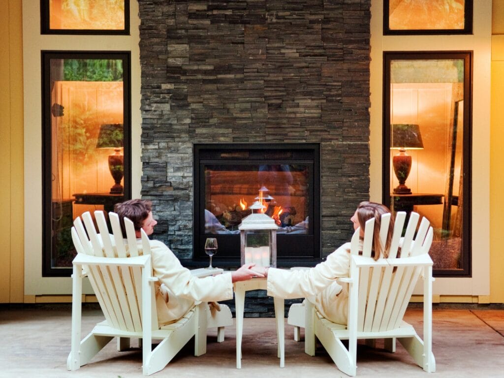couple enjoying wine by the fireplace at the farmhouse inn and spa hotel