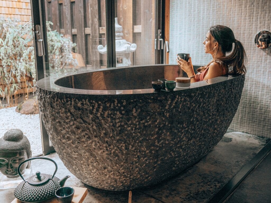 person on spa bath tub enjoying a cup of tea at the gaige house in glen ellen