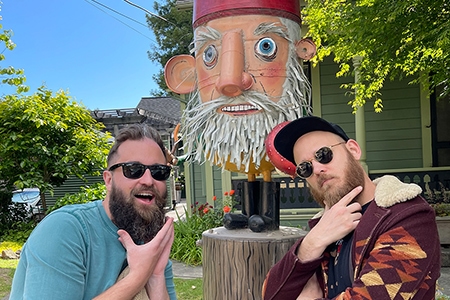 Two guys with beards in front of a huge Gnome