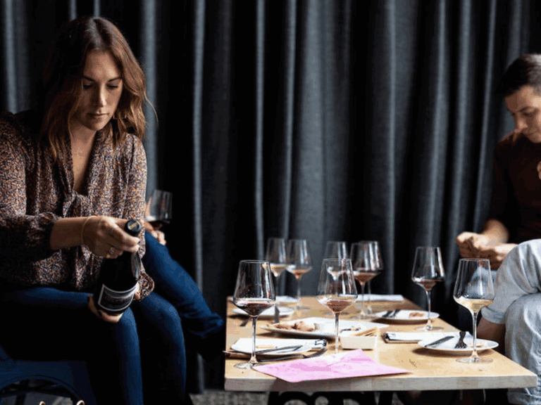 Woman reading wine label on bottle in idlewild wines in Healdsburg tasting room.