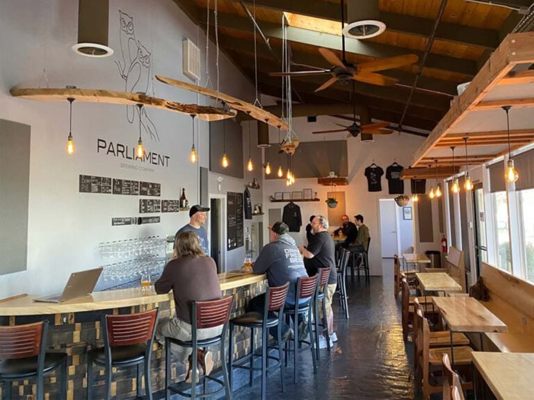 people sitting at the bar enjoying a beer at parliament brewing company