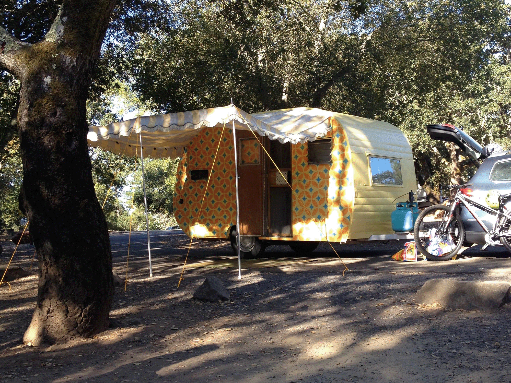 A travel trailer is set for the night in the shade of an oak tree at Spring Lake Regional Park, Santa Rosa