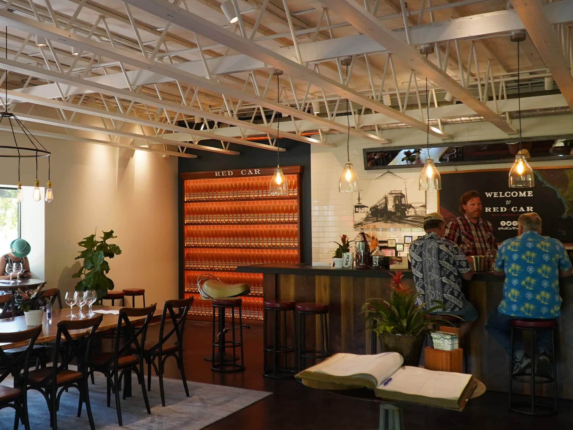 A modern tasting room with people standing at the bar