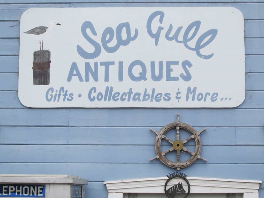 The sign for the antique store on the front of the building