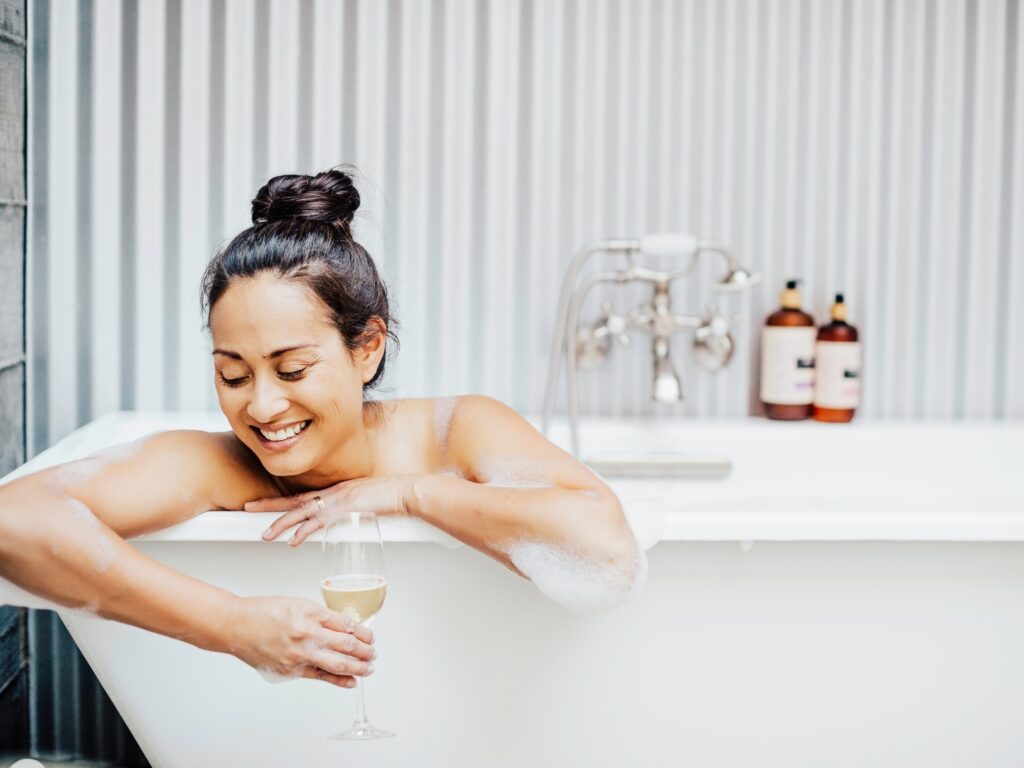 person in the spa bath tub having a glass of champagne at farmhouse inn, forestville