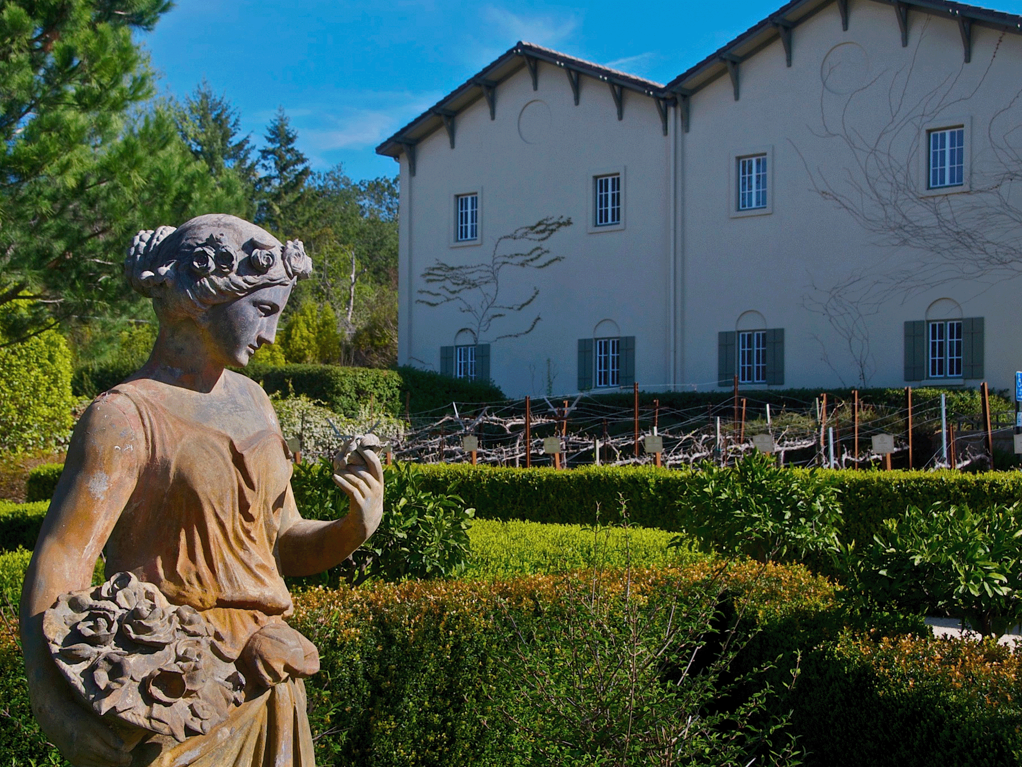 A sculpture of a person sits in the garden of the chateau