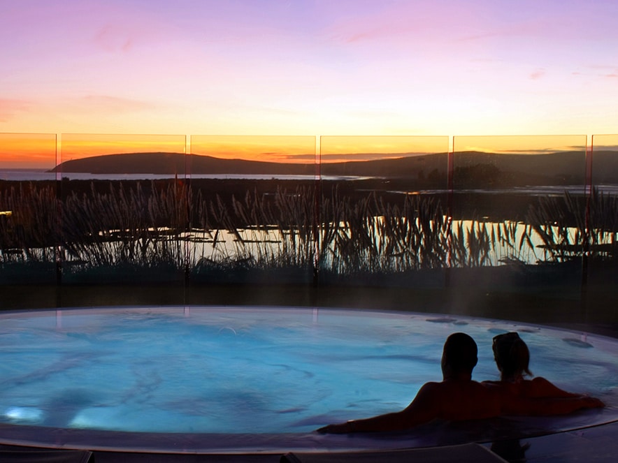 The silhouette of a couple relaxing in a spa under a fiery sunset sky at Bodega Bay Lodge in Sonoma County, California on the coast