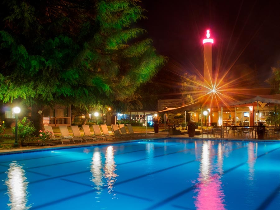 The retro sign for the hotel shines above the pool at night in Sonoma County