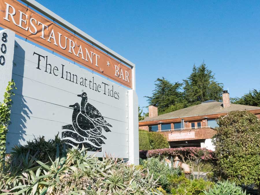 A sign for the hotel is surrounded by coastal plants in Sonoma County