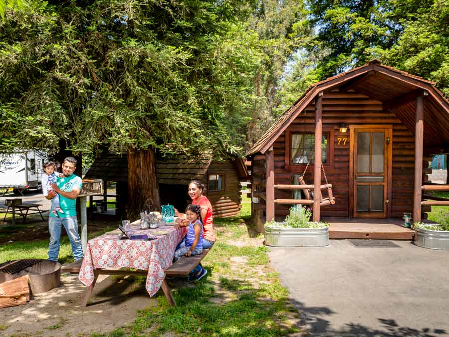 A family sits outside of a cabin in Sonoma County