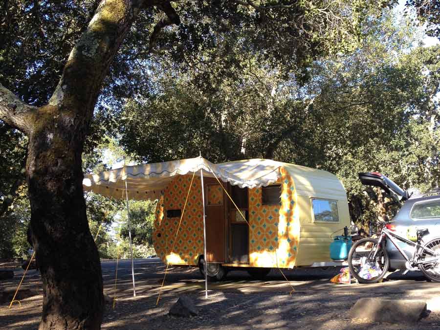 A vintage trailer is set up under the shade of an oak tree at Spring Lake Regional Park, Sonoma County