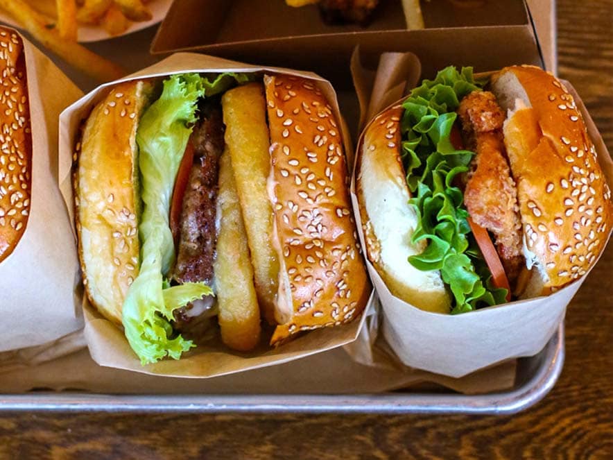 cheese burgers with tomatoes and lettuce in sesame buns