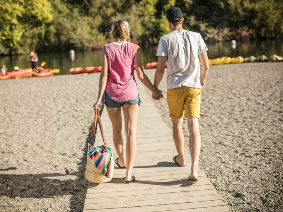 Two people walk toward the Russian River at Johnson's Beach in Sonoma County