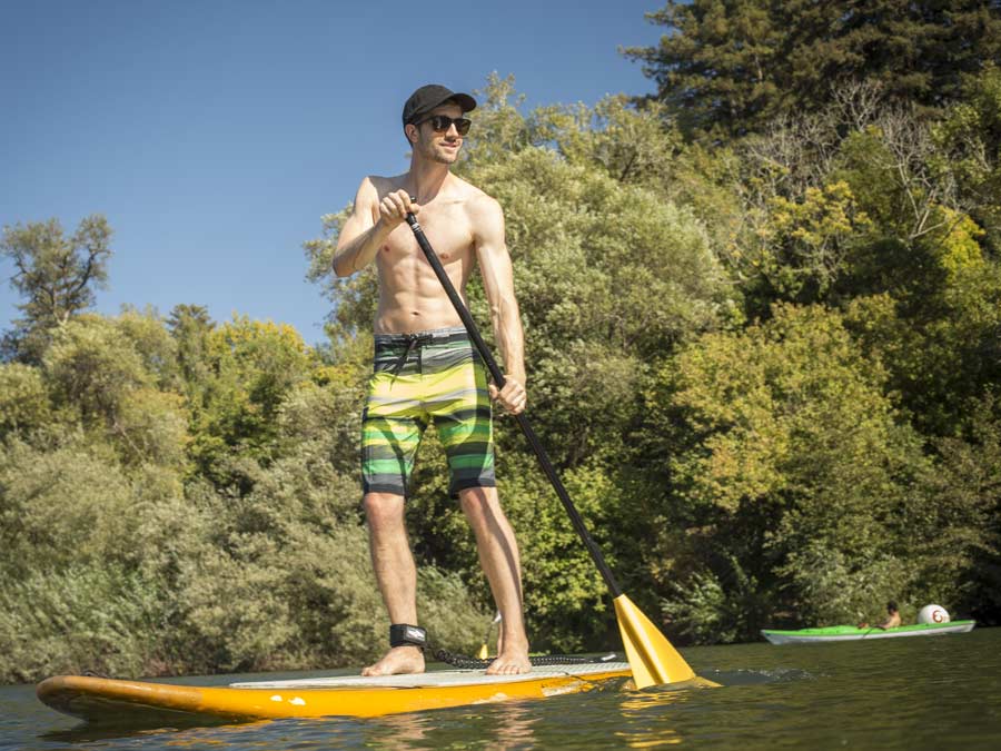 A man stands on a paddleboard in the Russian River in Sonoma County