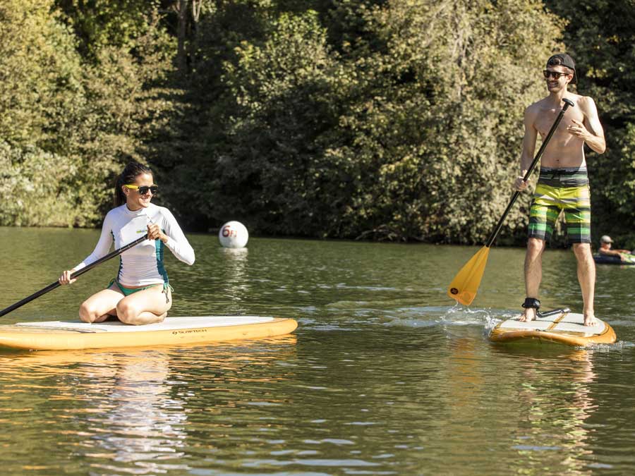 Two people paddle board along the Russian River in Sonoma County