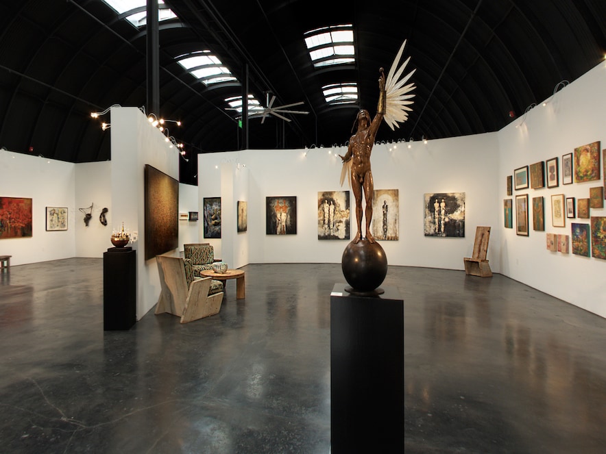 Interior of art gallery with a concrete floor, decorated with sculpture and paintings 