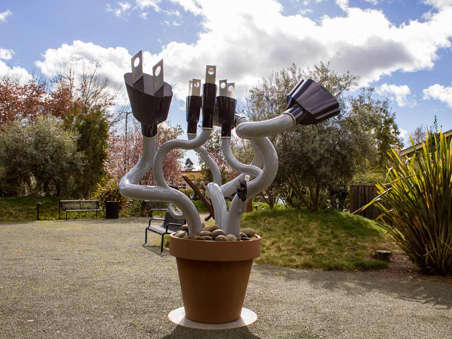 A sculpture of power plugs in a giant flower pot