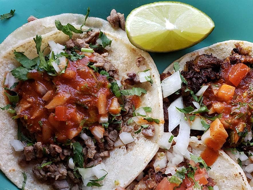 carne asada tacos on flour tortilla with salsa and lime