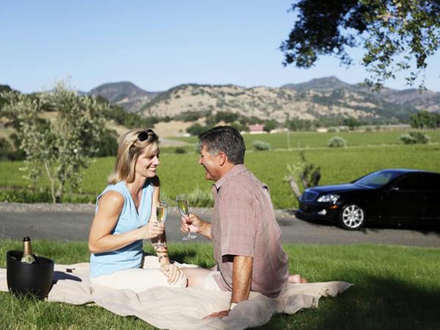 Image of couple in front of car from Beau Wine Tours