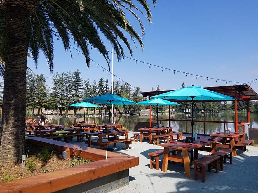 outdoor tables on patio with views of pond