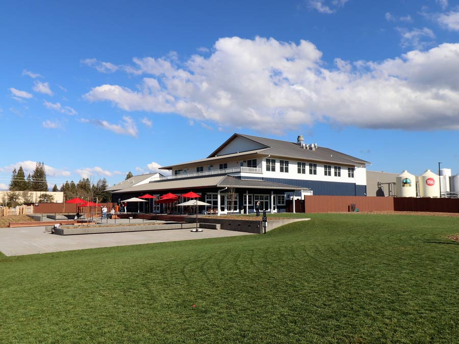 The exterior of the brewery has a big lawn and patio