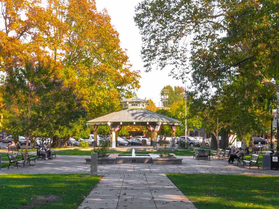 The gazebo is surrounded by trees and the town plaza