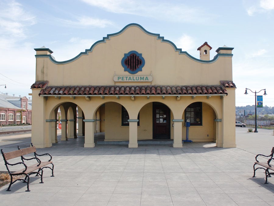 The light yellow exterior of the train station has a few benches