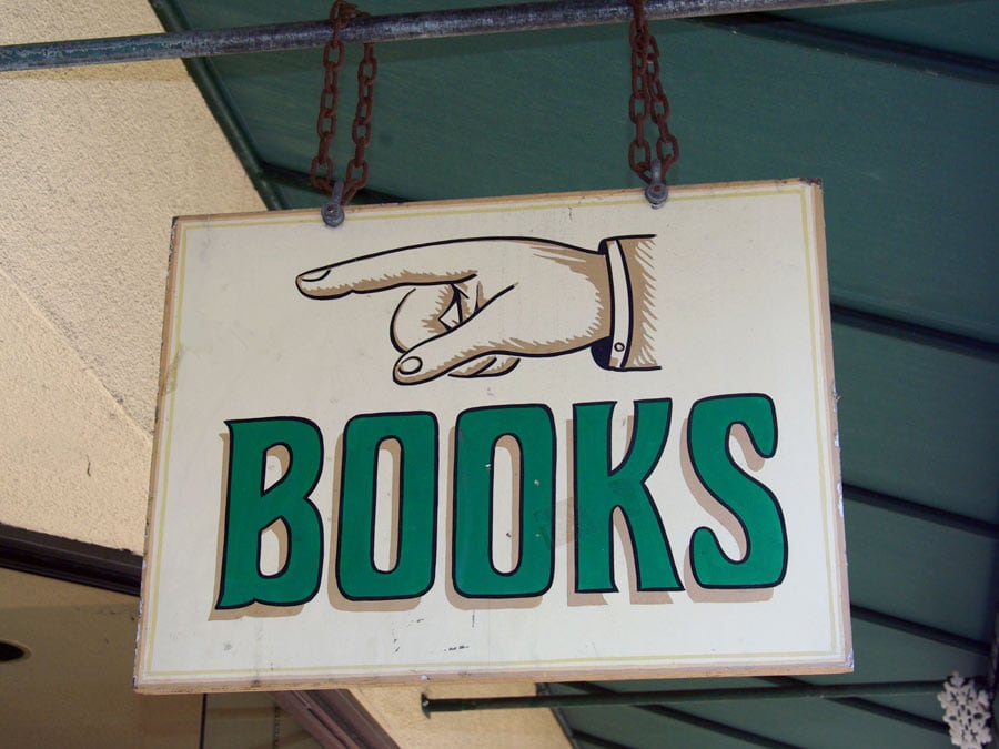 A sign says Books with a hand pointing