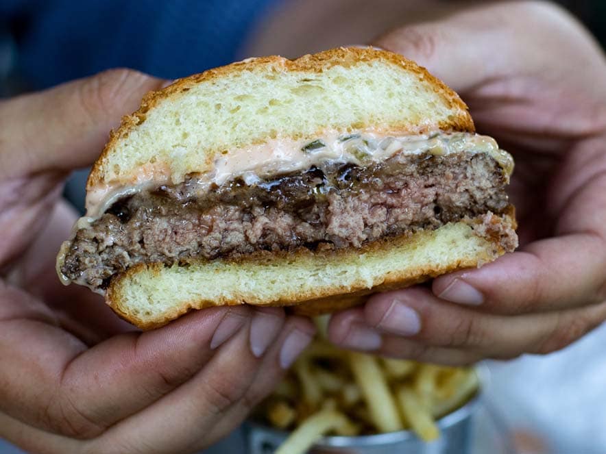 two hands holder burger with sauce