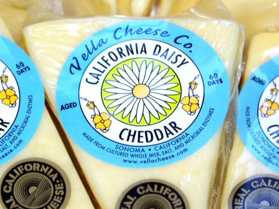 A block of cheese with a daisy on the label