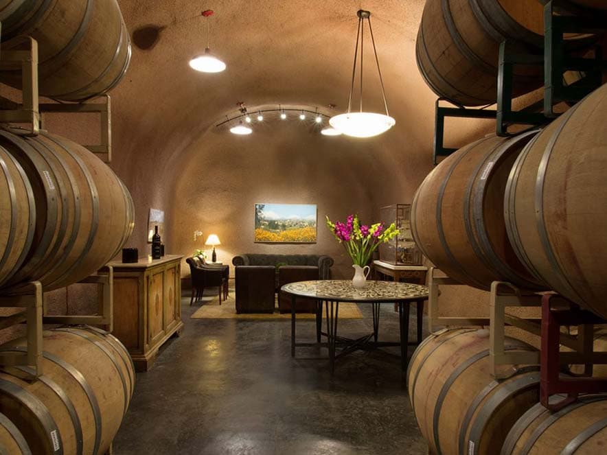 wine cave with wine barrels and dining tables