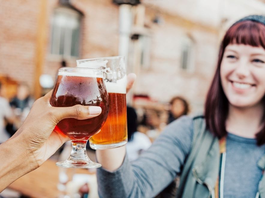 Picture of two people toasting a glass of beer