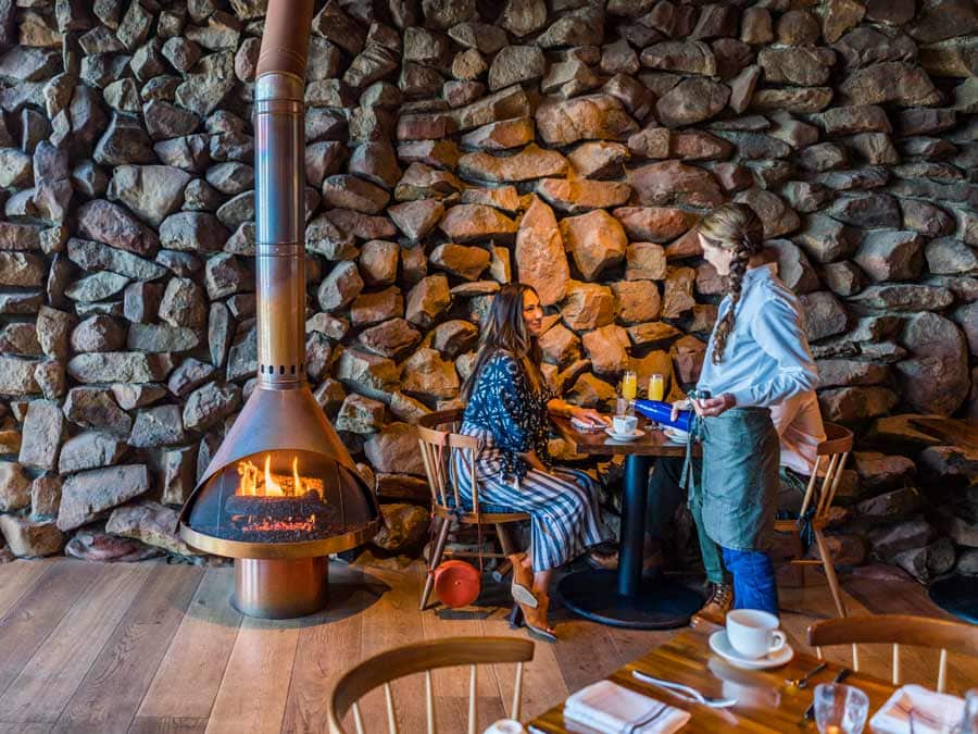 Dine by the cozy fireplace at Coast Kitchen at Timber Cove Resort, Jenner