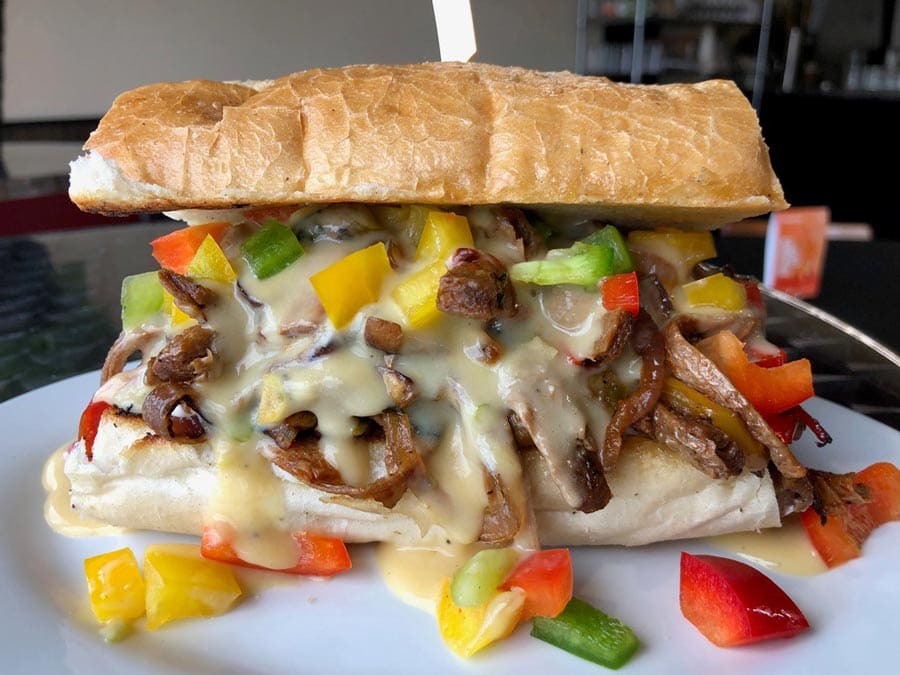 A sandwich with vegetables and melted cheese sauce