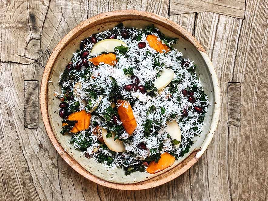 colorful salad with grated cheese in wooden bowl