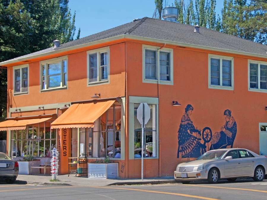 The exterior of the building with a mural of ladies spinning at Spinster Sisters, Santa Rosa