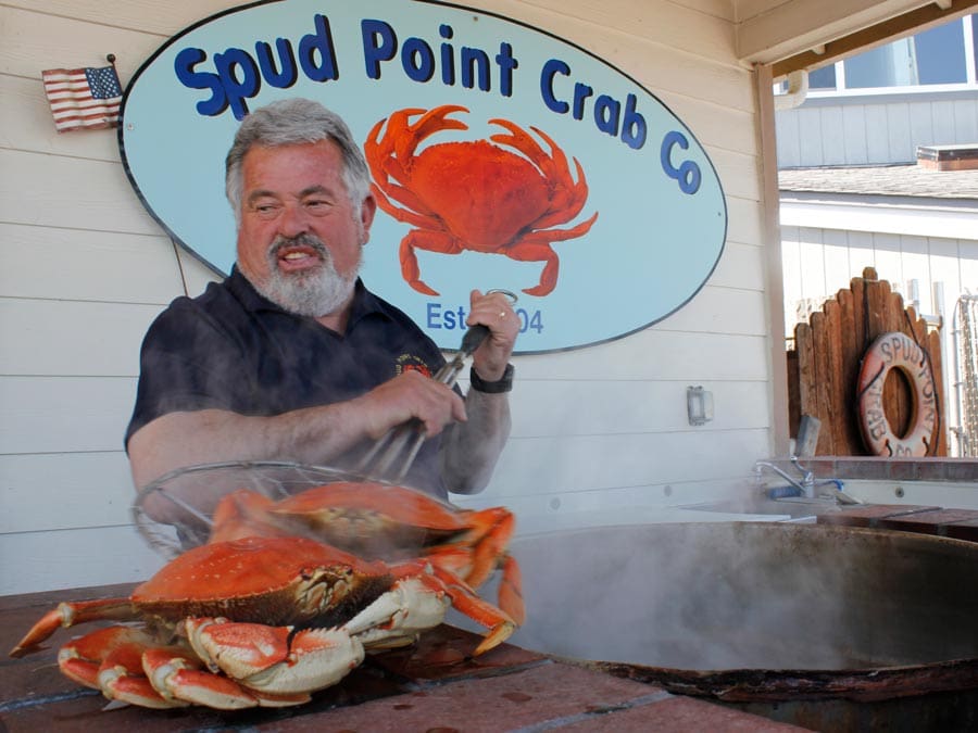 A man cooks a crab at Spud Point Crab Company, Bodega Bay