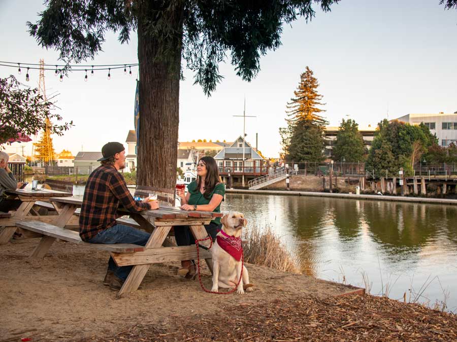 People dine at a picnic table along the river