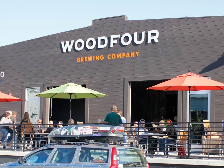 Umbrellas and people dot the outdoor patio at Woodfour Brewing Company, Sebastopol