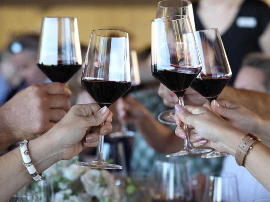 Four glasses full of red wine toasting