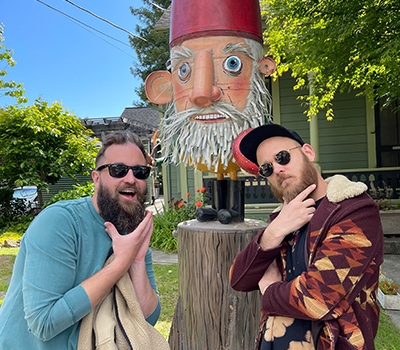 Two guys posing infront of gnome