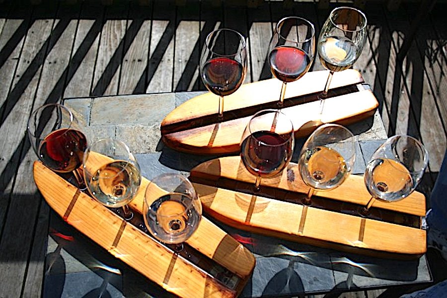 Wine glasses are delivered on small wooden surfboards at Gourmet Au Bay