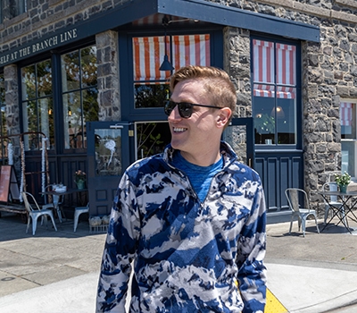 Guy walking in front of store