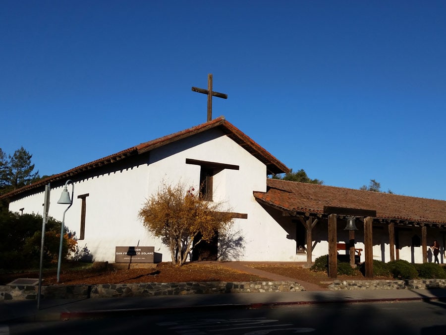 The white stucco building against the bright, blue sky