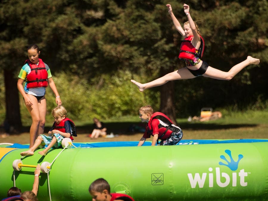 Kids jump off the inflatable water playground in the lake at Spring Lake Regional Park in Sonoma County