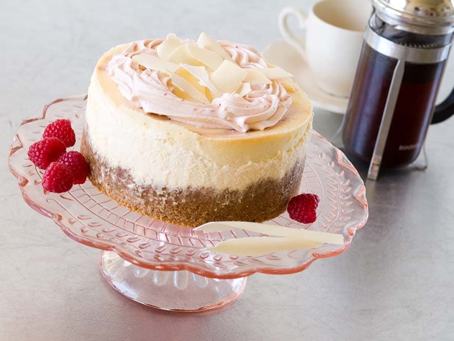 cheesecake with white chocolate shavings and raspberries